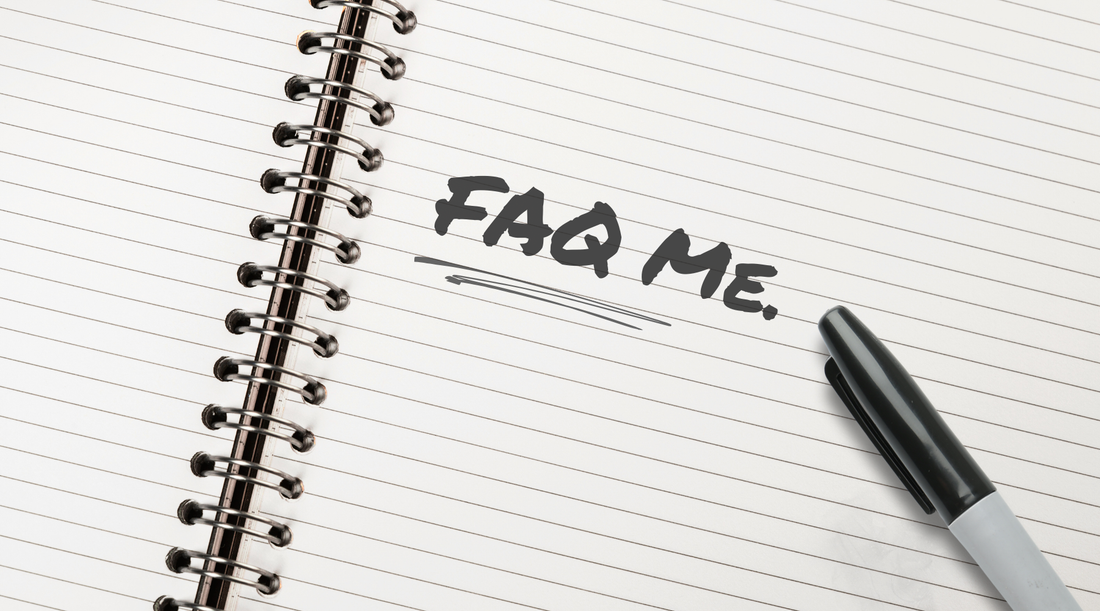 "FAQ Me." is written in black marker on a white lined notebook. A black Sharpie pen sits next to the text.
